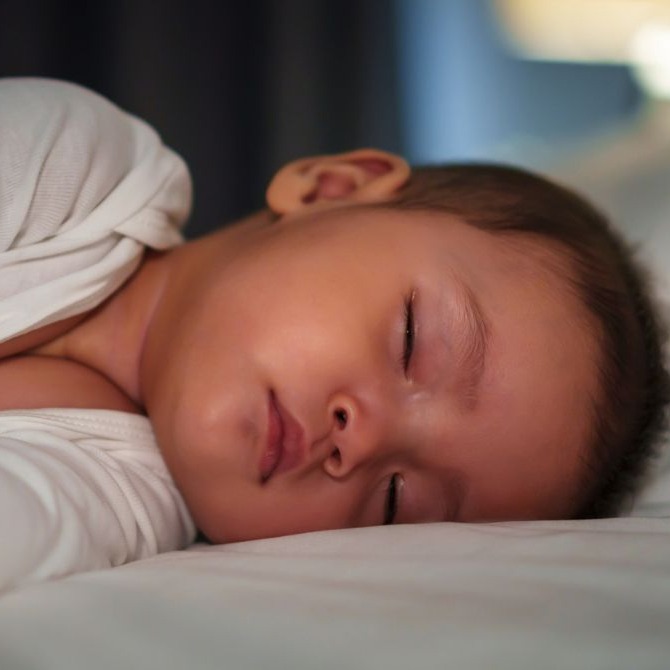 A toddler sleeping in their bed