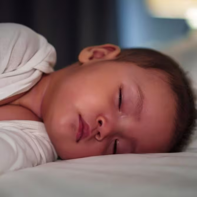 A toddler sleeping in their bed