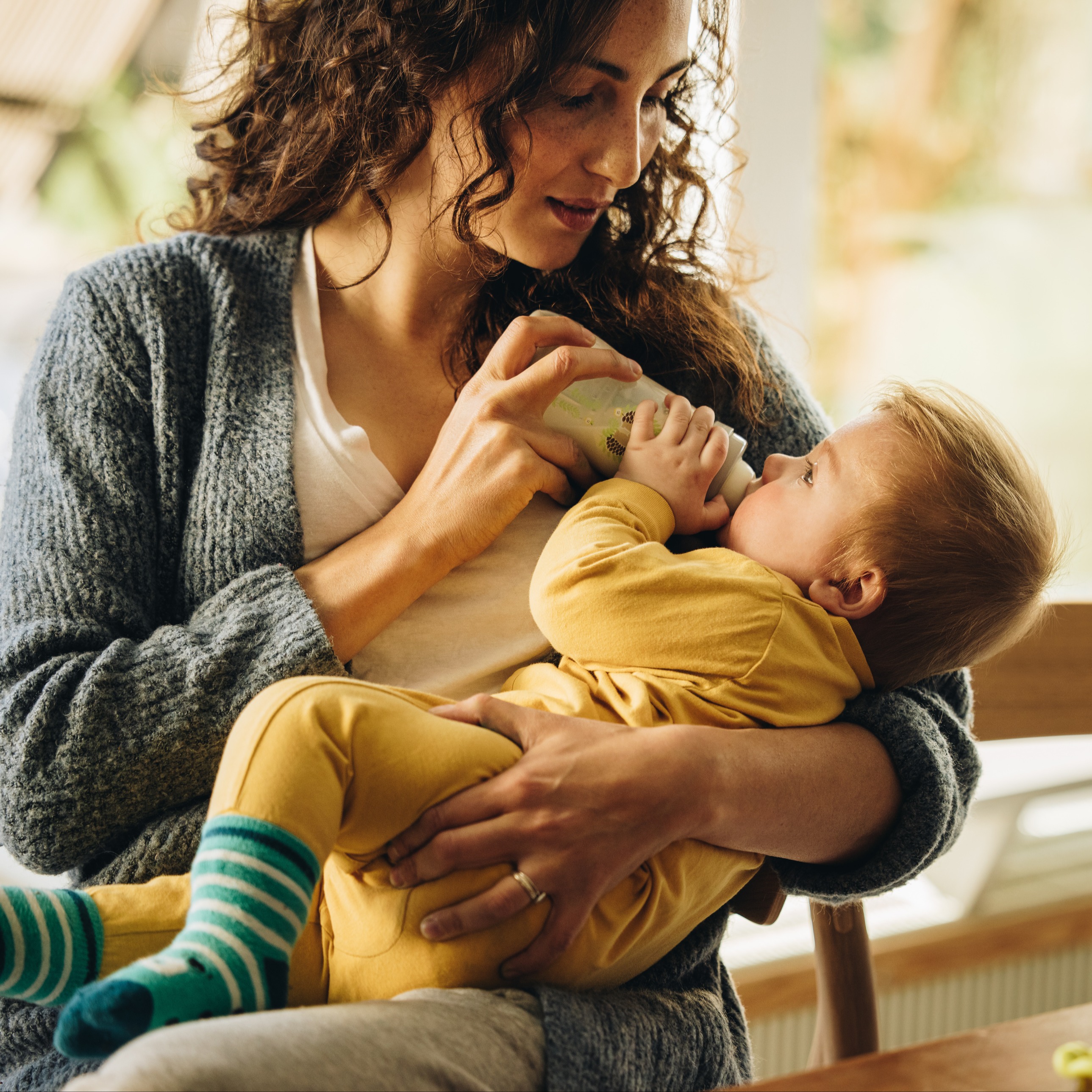 Woman bottle feeding an infant.