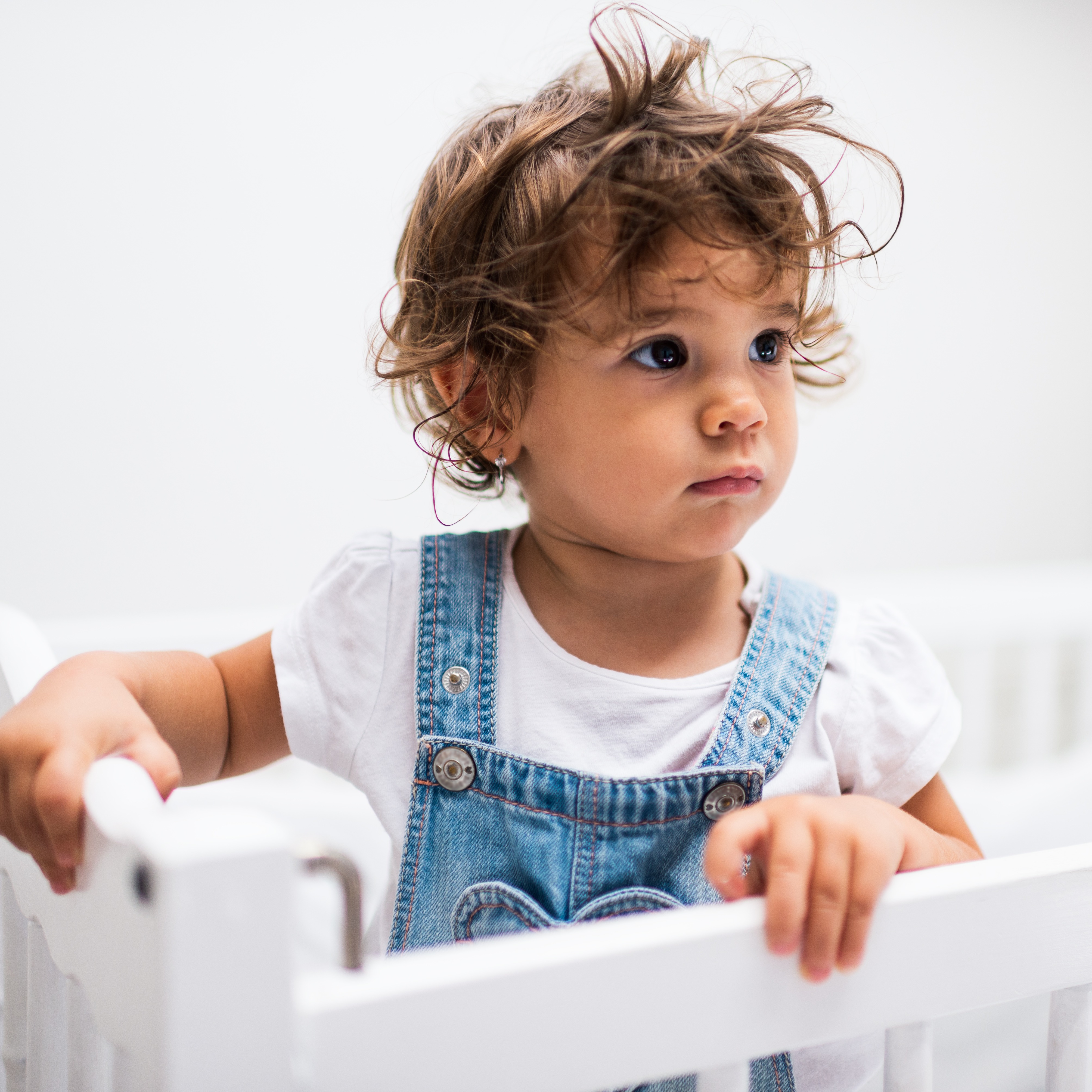 16 month old standing in crib.