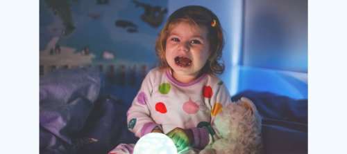 Toddler sitting up in bed after having nightmare or night terror