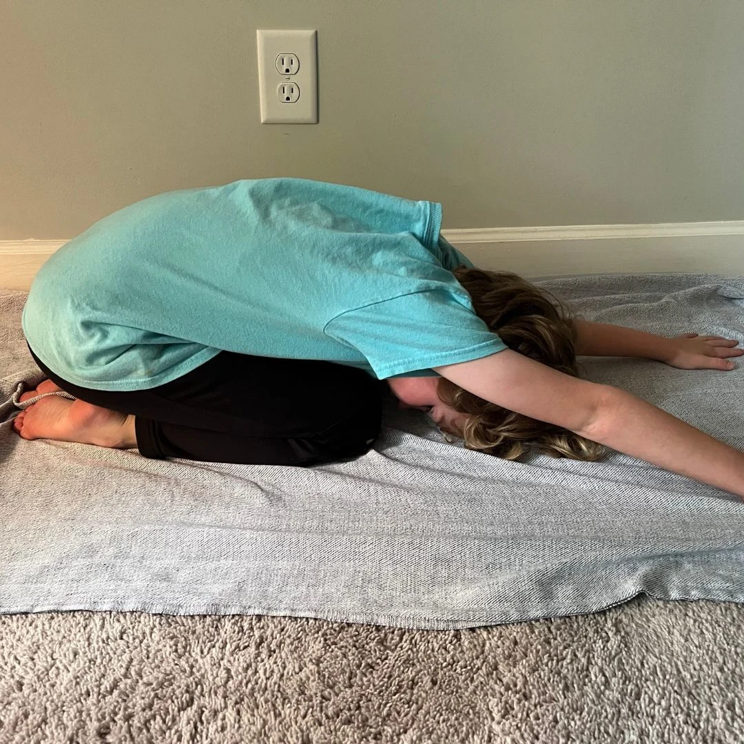 A child doing a rock yoga pose.
