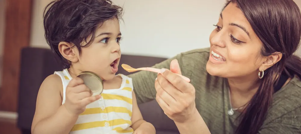 A mother trying to feed her child.
