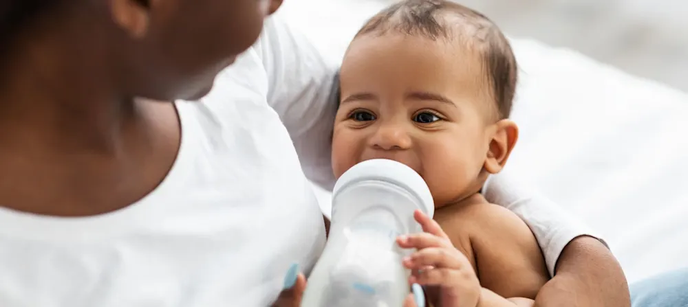 A mother feeding a bottle to her child.