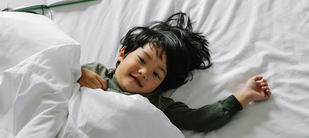 Toddler laying in bed going for a nap.