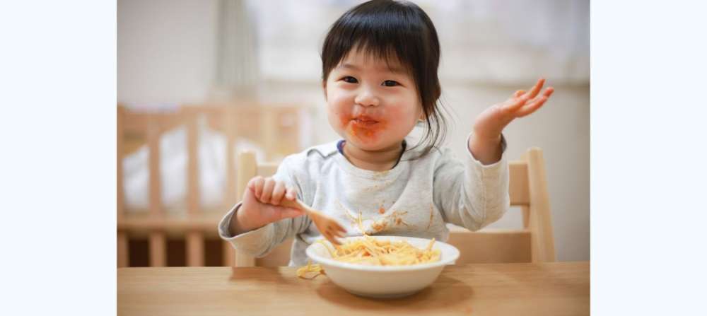 Toddler eating bowl of spaghetti