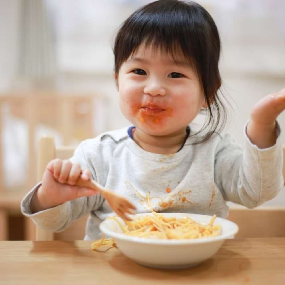 Toddler eating bowl of spaghetti