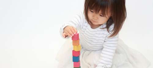 A 15 month old stacking blocks.