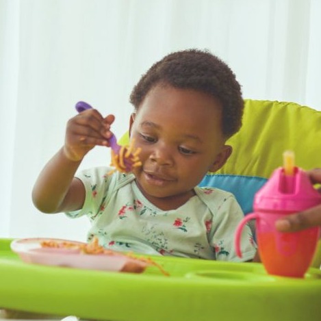 A baby eating in a high chair.