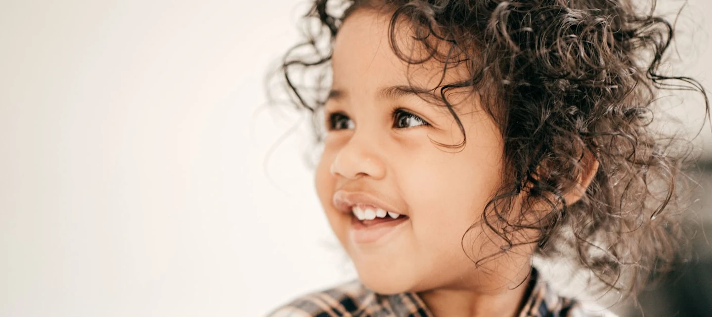 A young toddler smiling. | Huckleberry