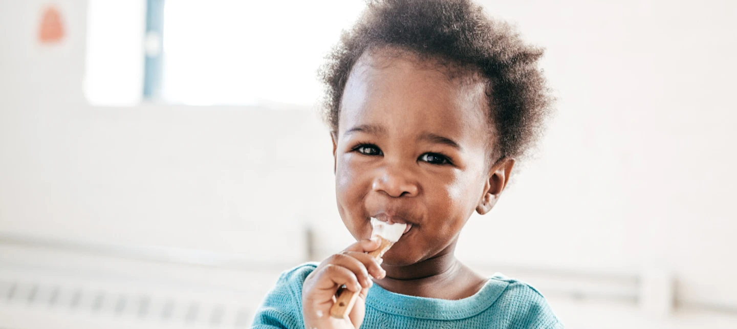 Toddler eating yogurt | Huckleberry