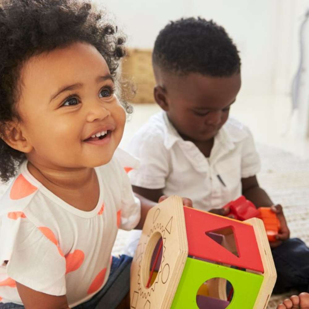 An 18 month old and another baby playing together.