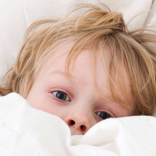 Child hiding under blanket