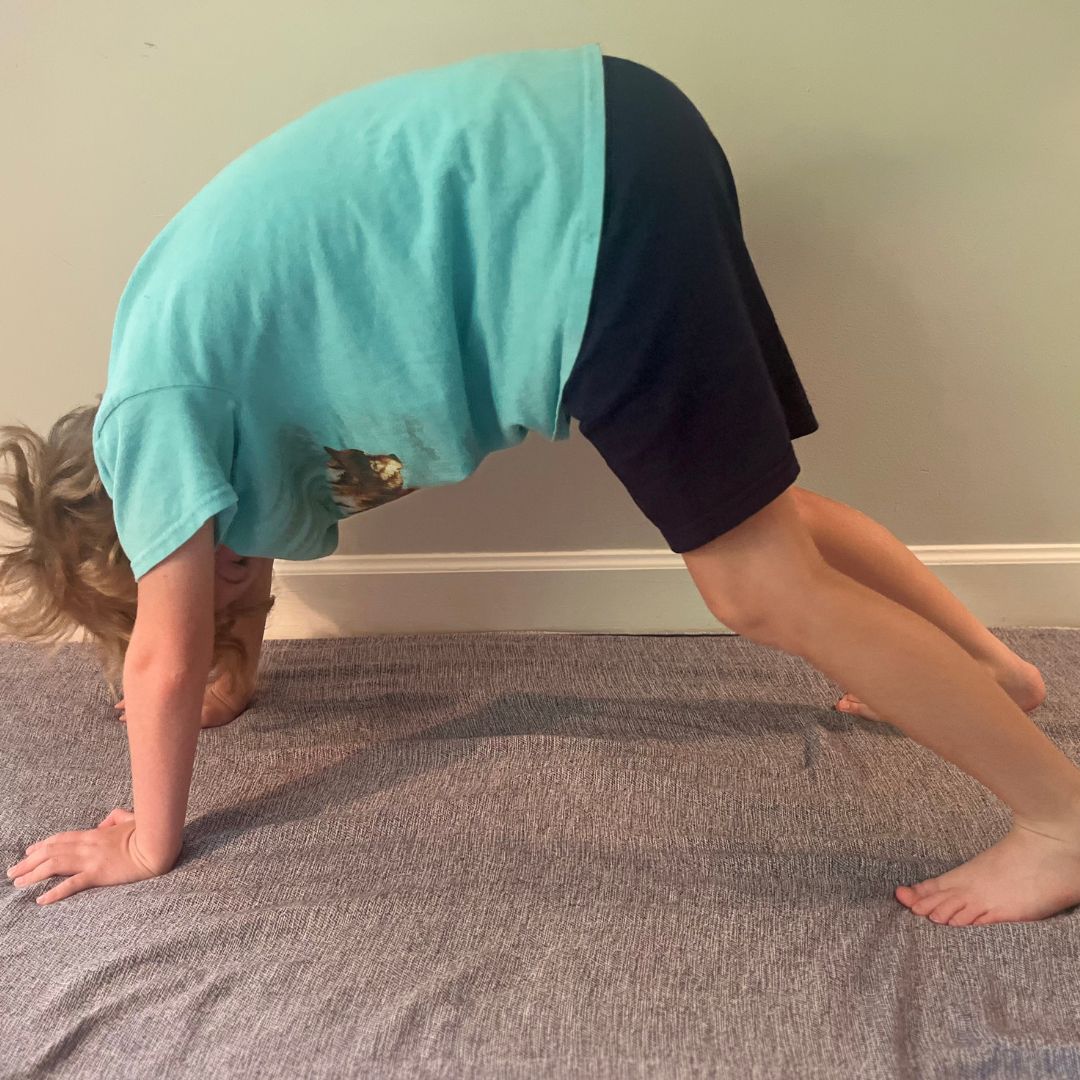 A child doing a down dog yoga pose.