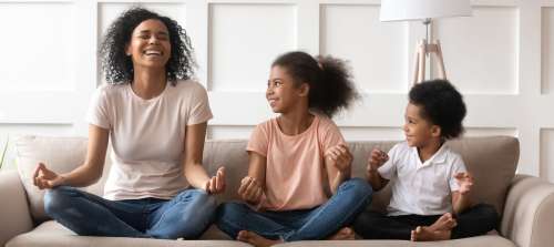 A mother role modeling meditation to her children.