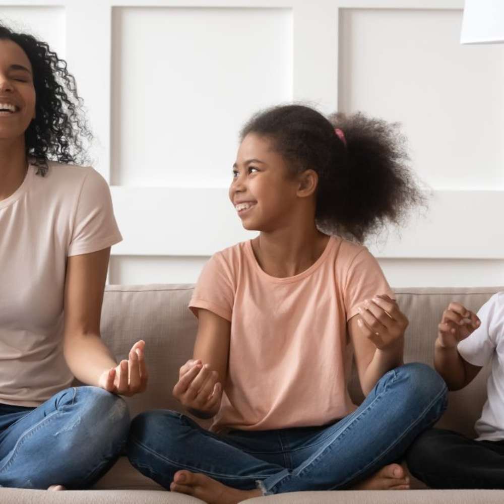 A mother role modeling meditation to her children.