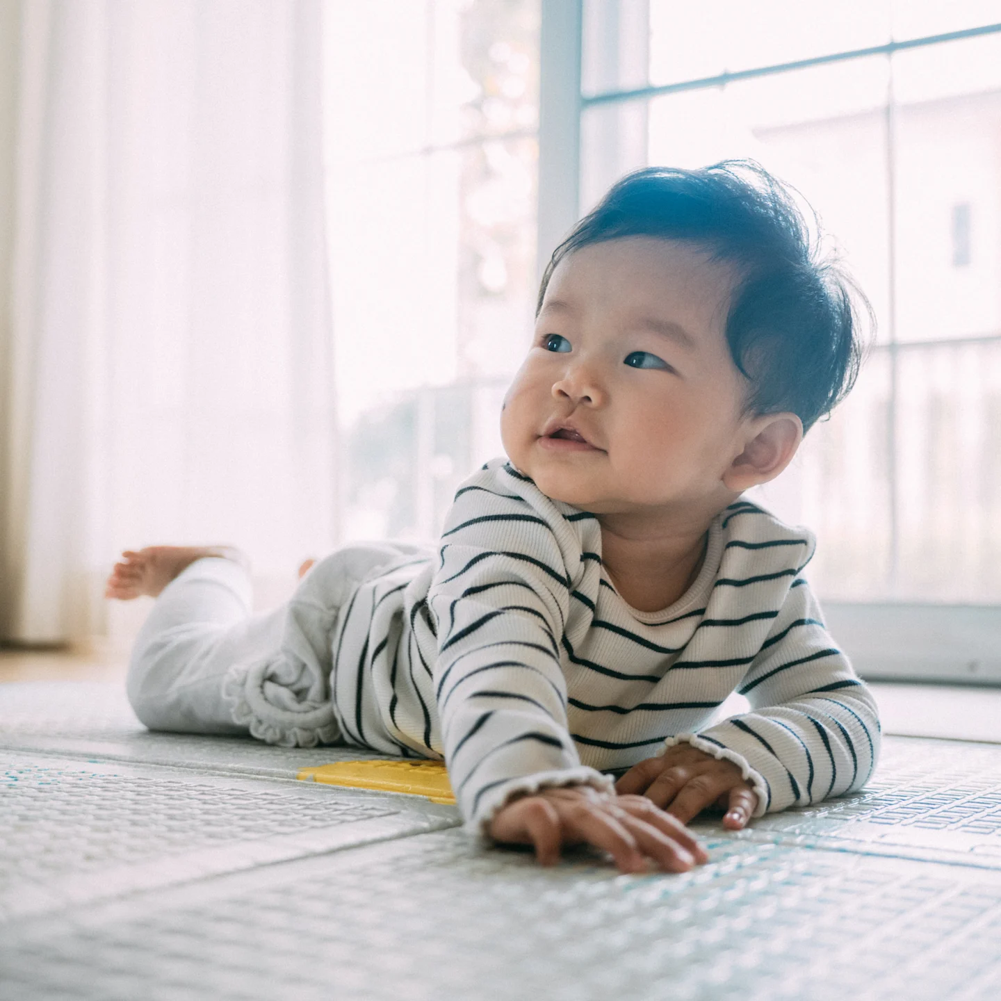 A baby boy belly crawling.