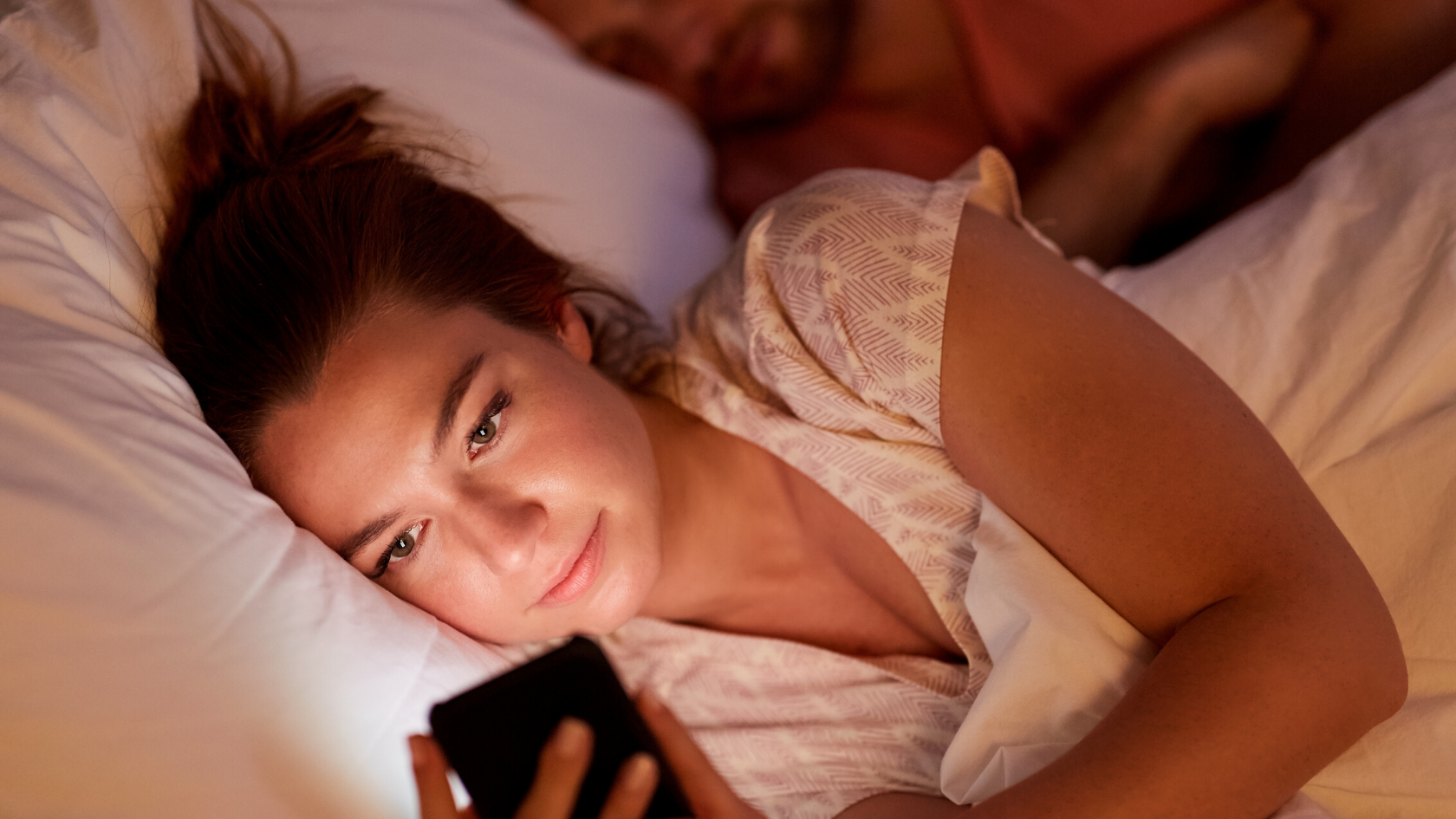 Woman laying in bed on cellphone