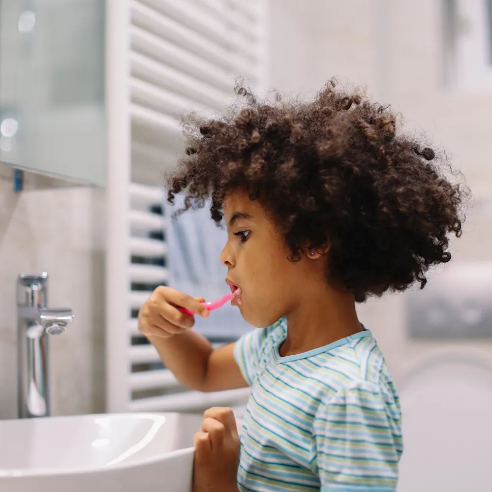 Child brushing their teeth before bed.
