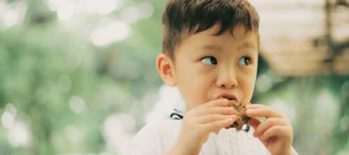 A boy eating a carbohydrate treat.