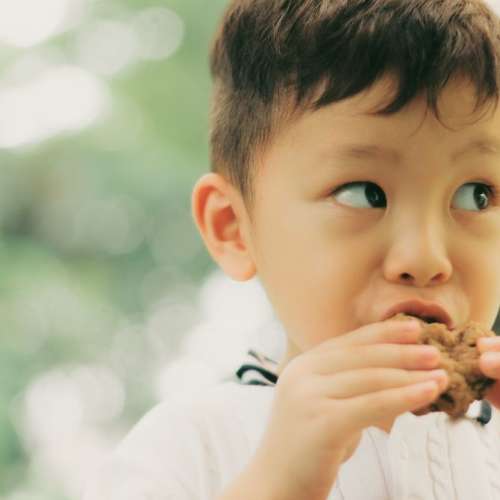 A boy eating a carbohydrate treat.