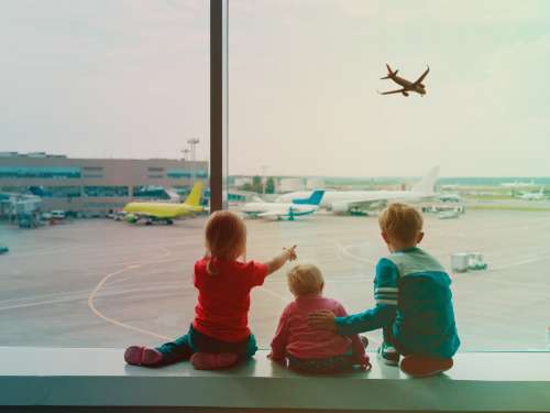 Kids at airport watching airplanes take off