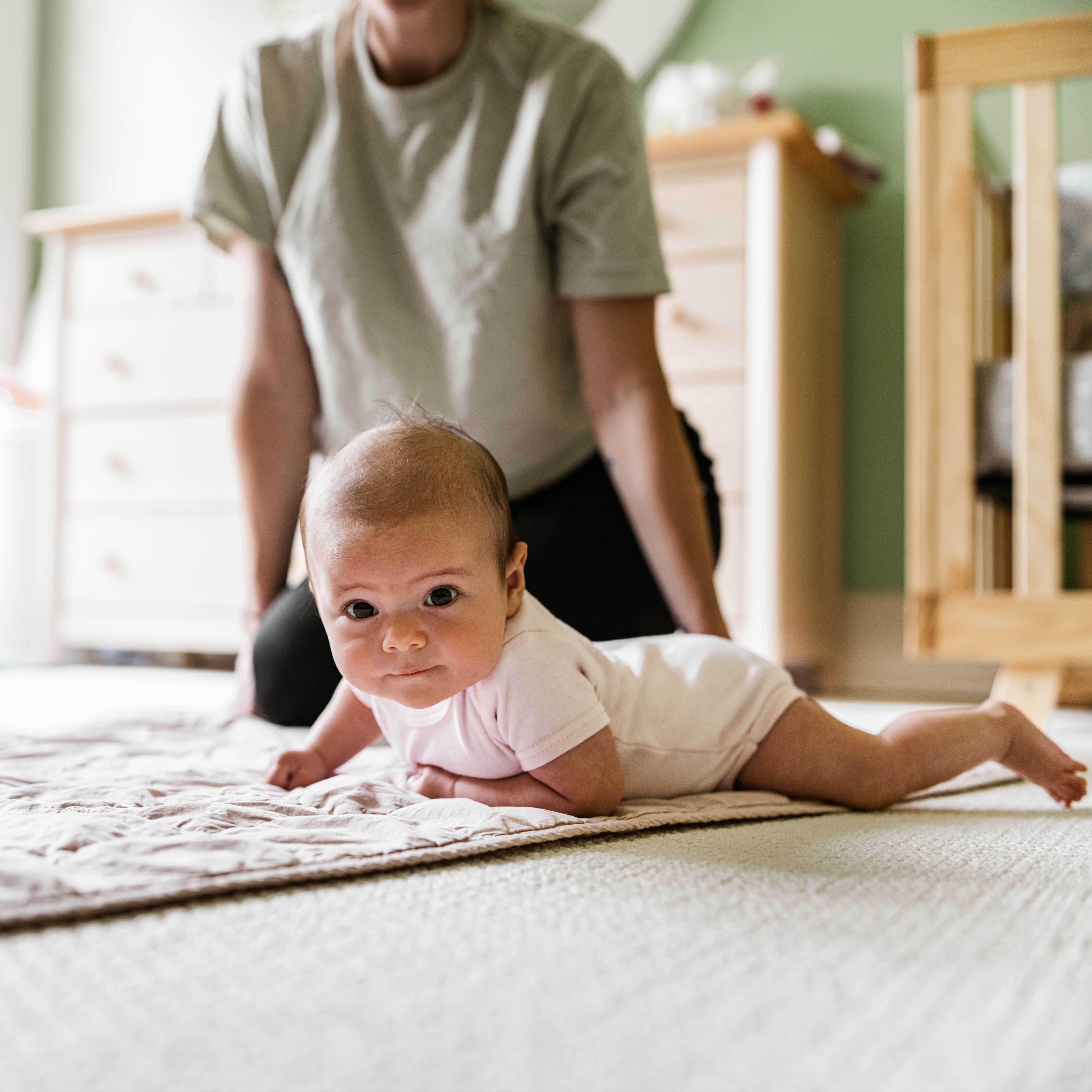 Baby on the floor working on rolling over