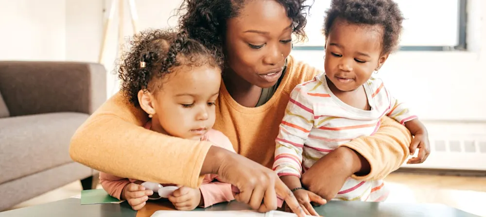 A mother reading with her two children.
