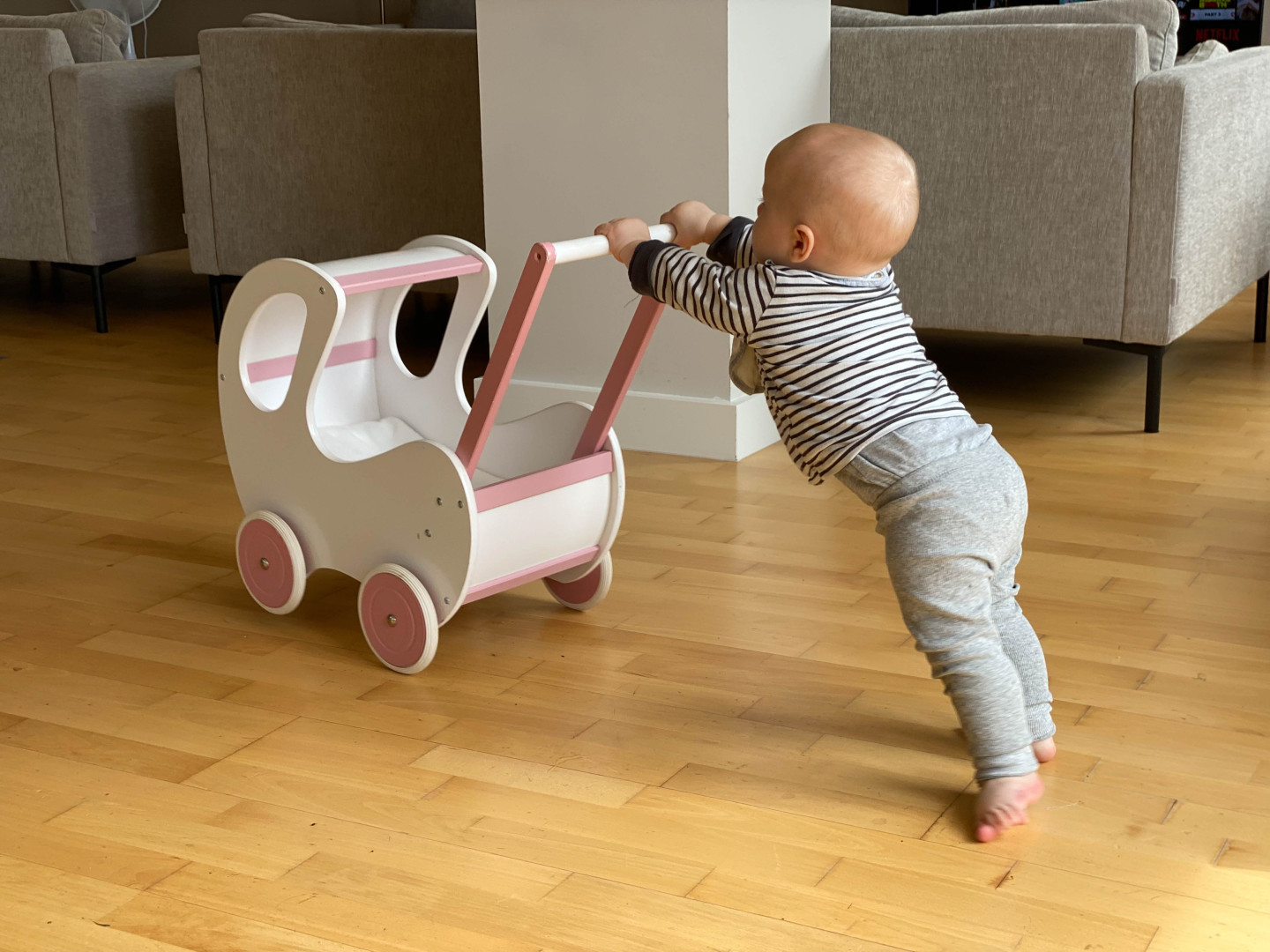 A baby using a push-along walker.