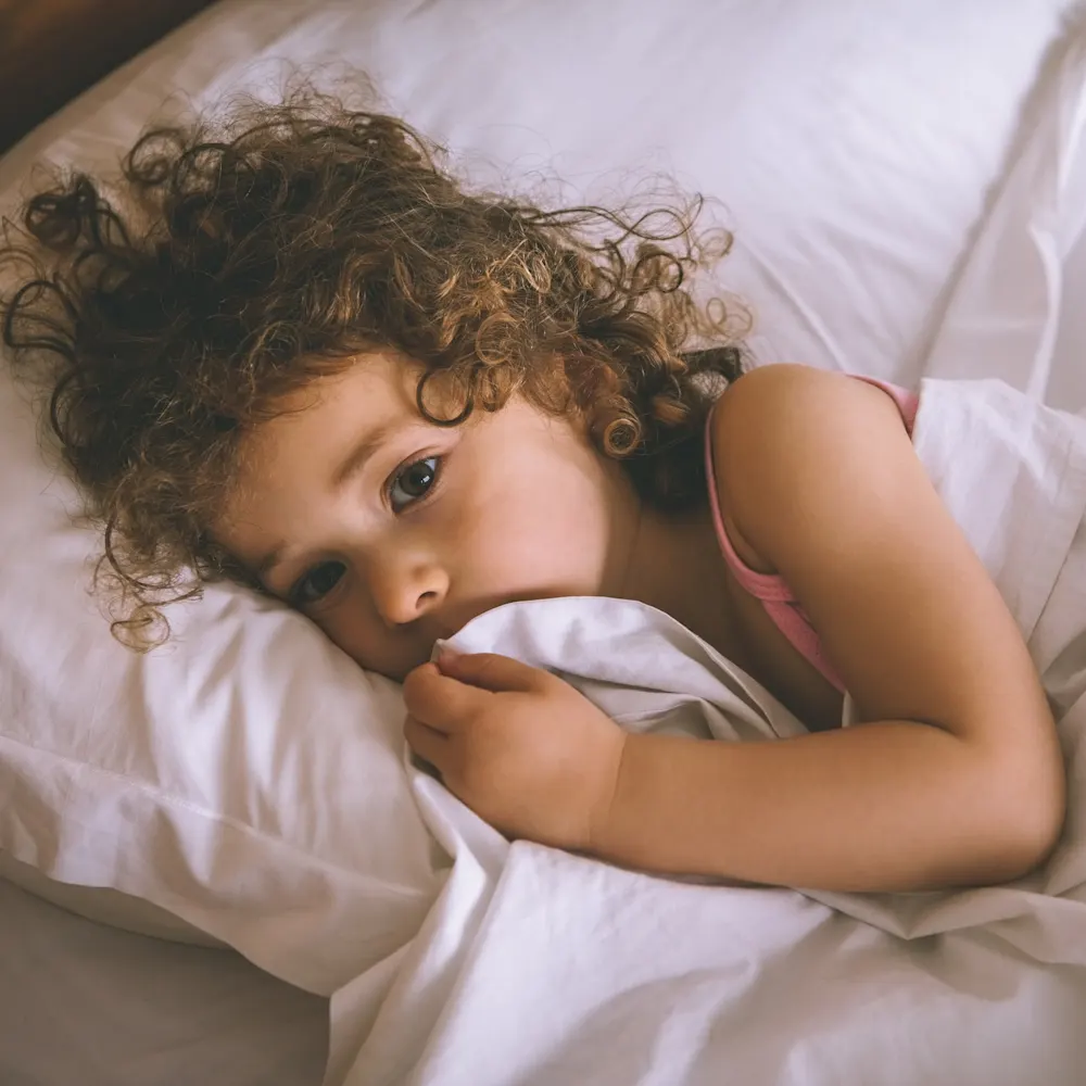 Toddler in bed still awake.