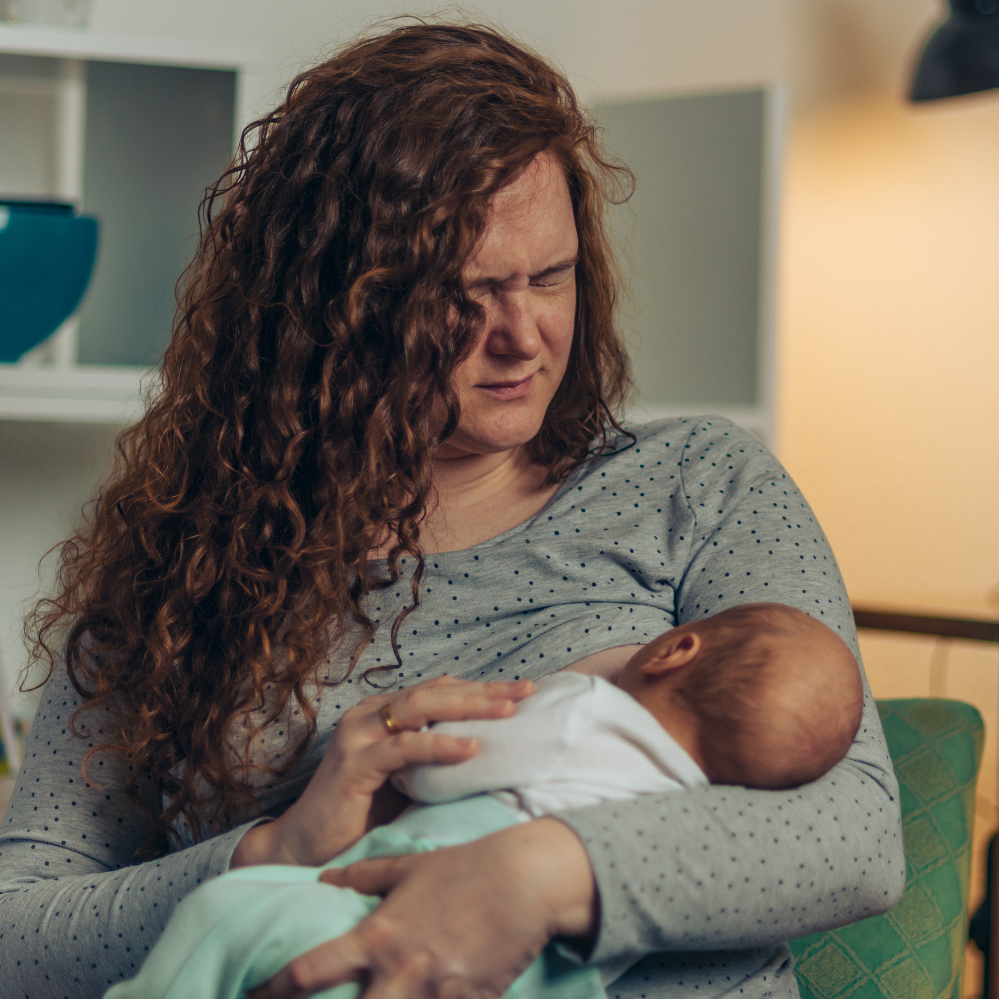 Woman in pain while breastfeeding with sore nipples