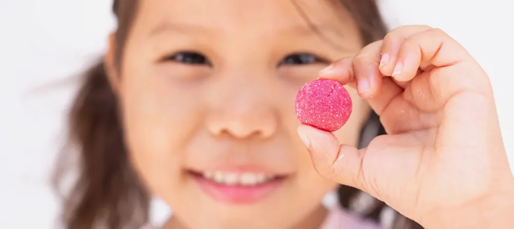 A child holding a melatonin gummy.