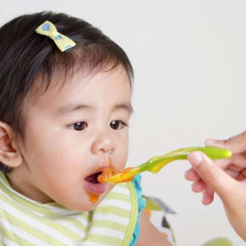 Baby eating beans safely being fed through baby led weaning