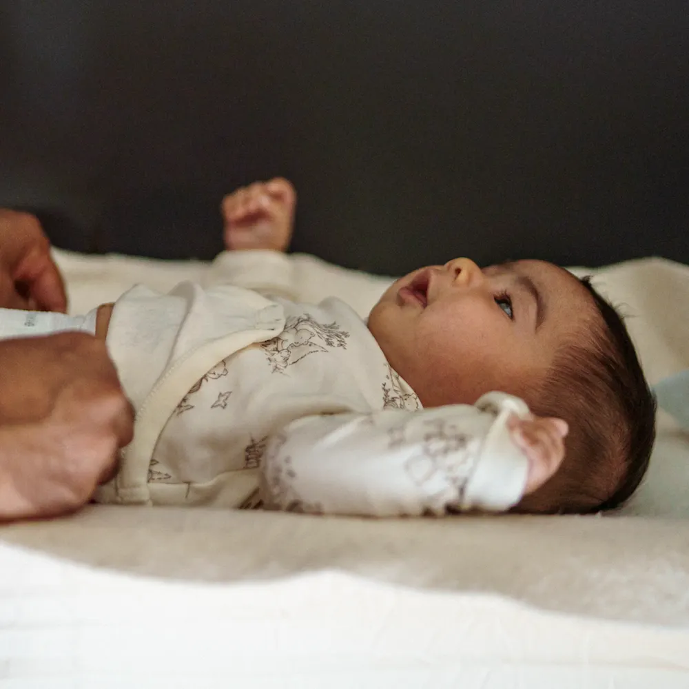 Father changing newborn baby on his night shift