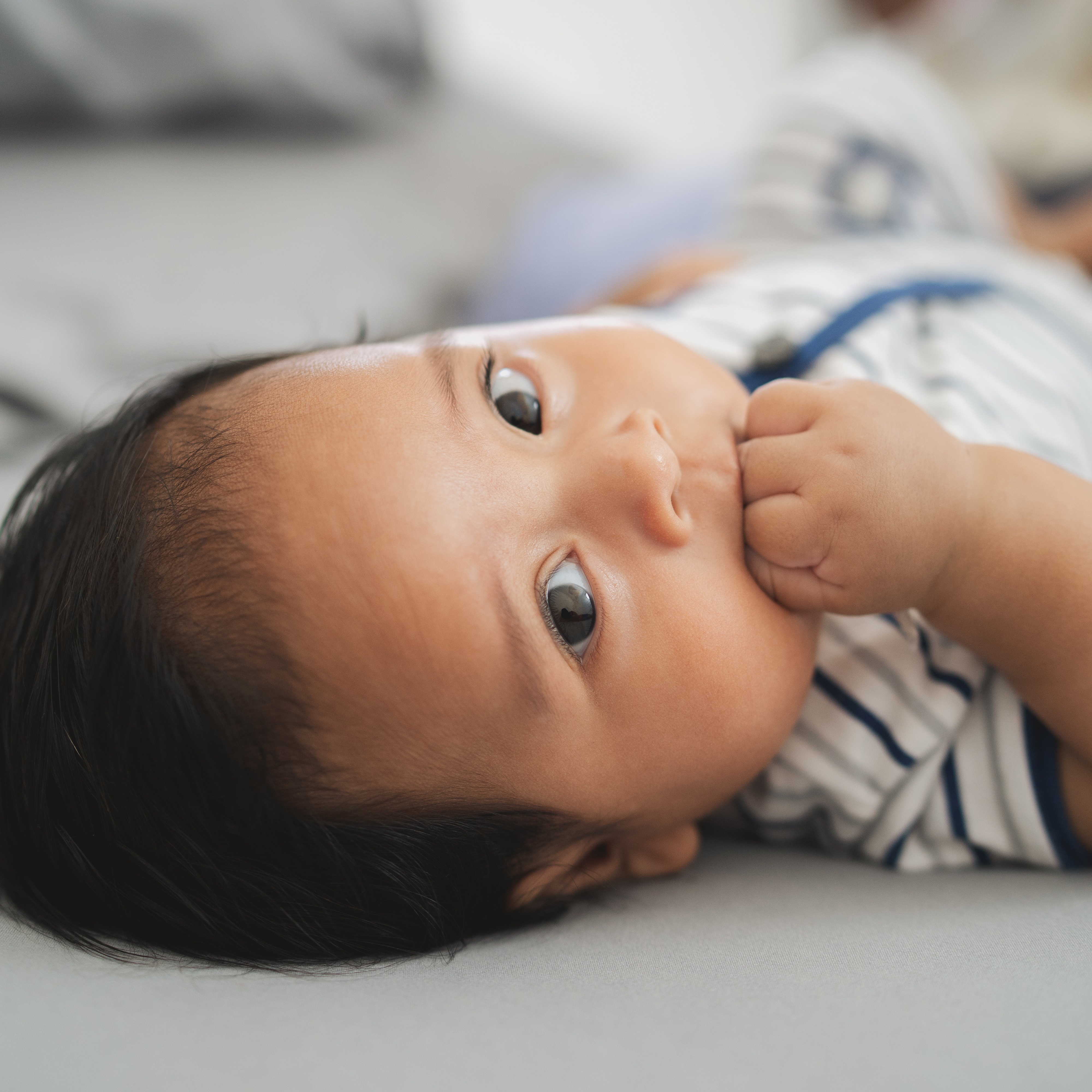 Baby content and self-soothing with hands in mouth