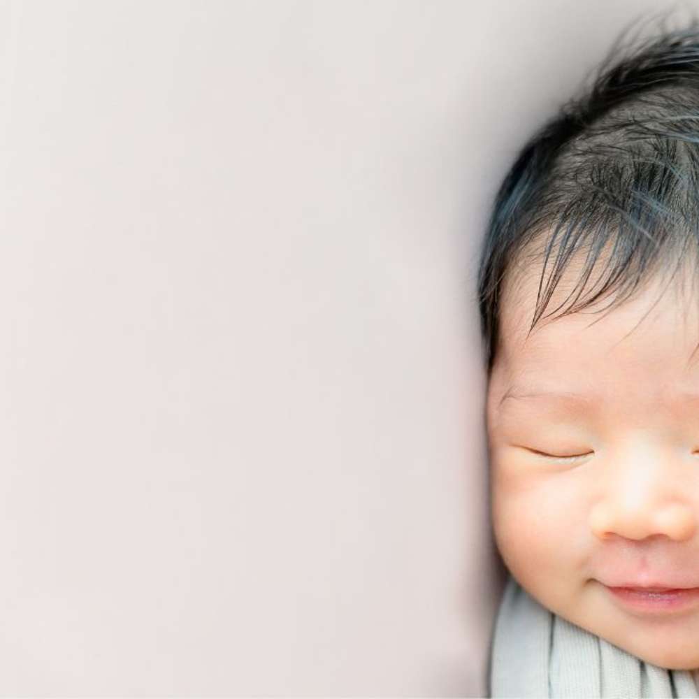A baby sleeping and smiling while sleeping. 