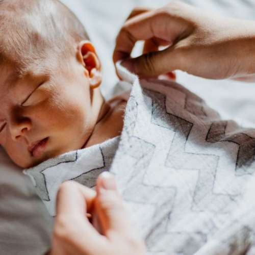 A baby swaddled in a blanket.