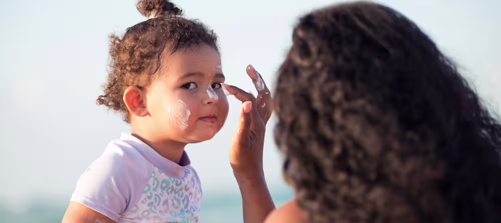 Mom applies safe sunscreen for baby to protect her skin