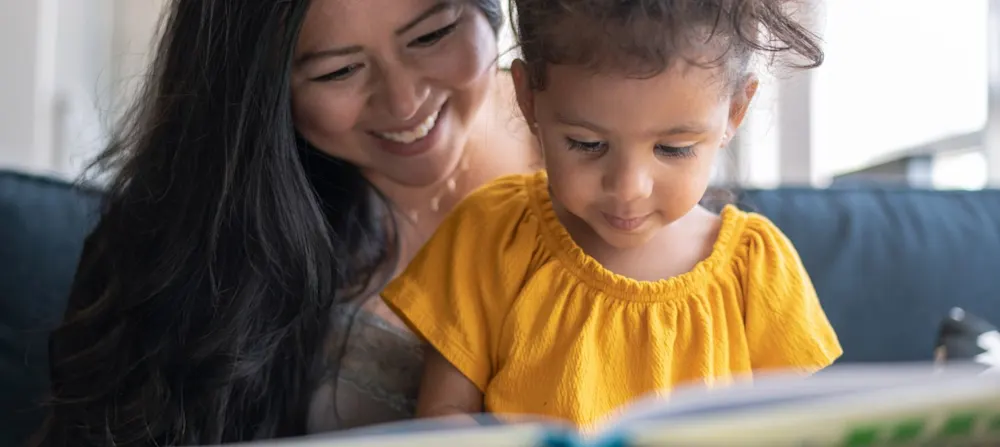 A mother and child reading a book.
