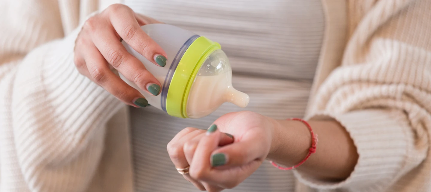 Caregiver testing formula on their wrist. | Huckleberry