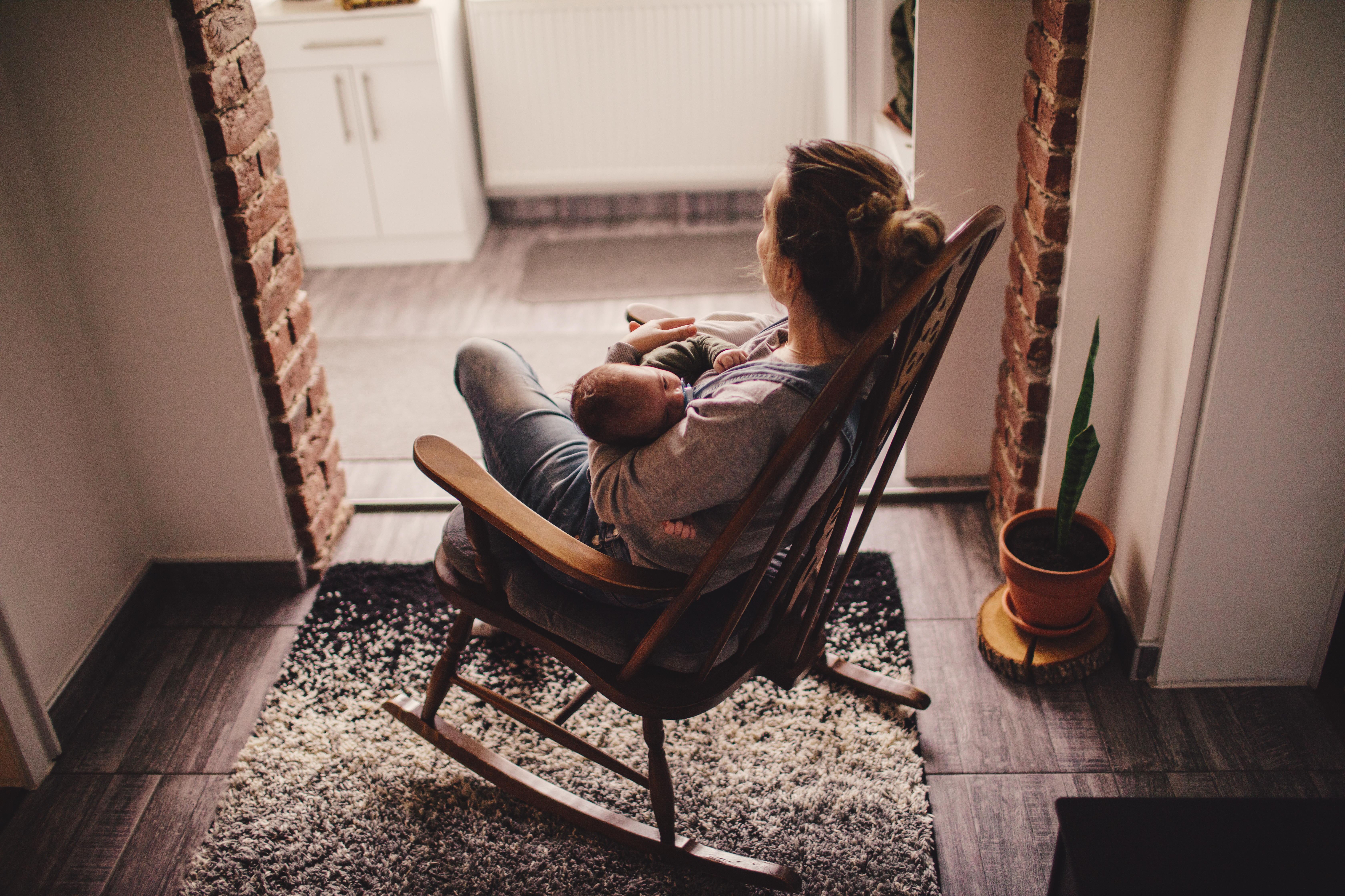 Mom rocking baby to sleep in rocking chair