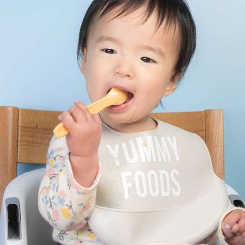 A child eating food with a spoon.