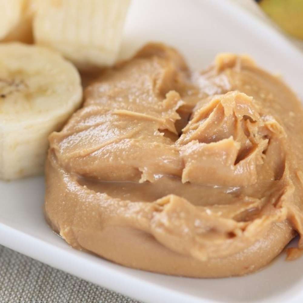 Peanut butter on bread with banana slices on a plate