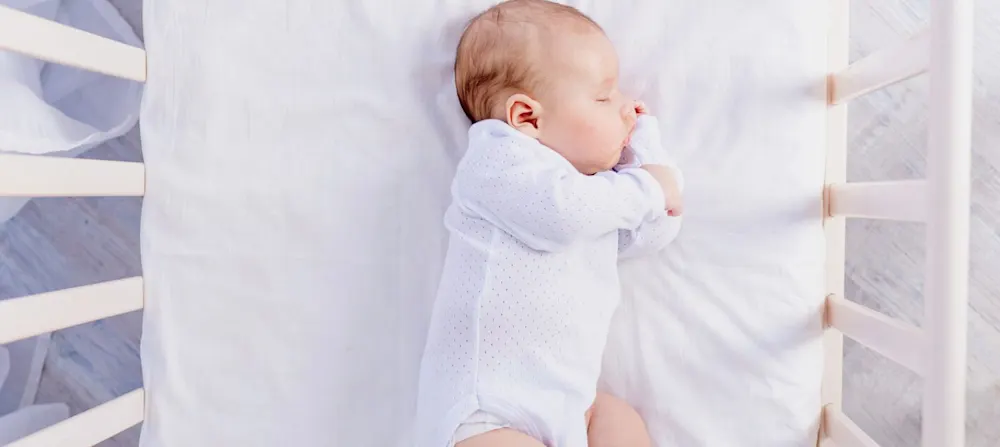 A baby sleeping in a crib.