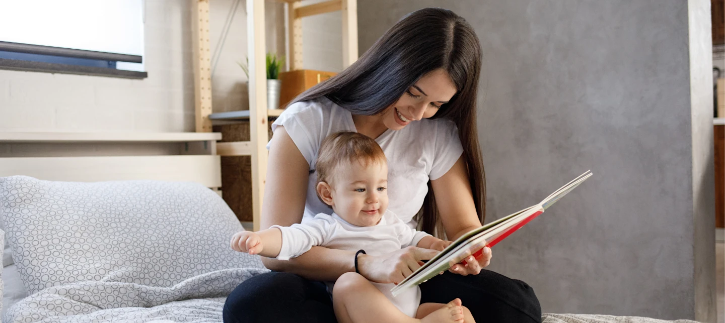 Baby reading a bedtime book with parent. | Huckleberry