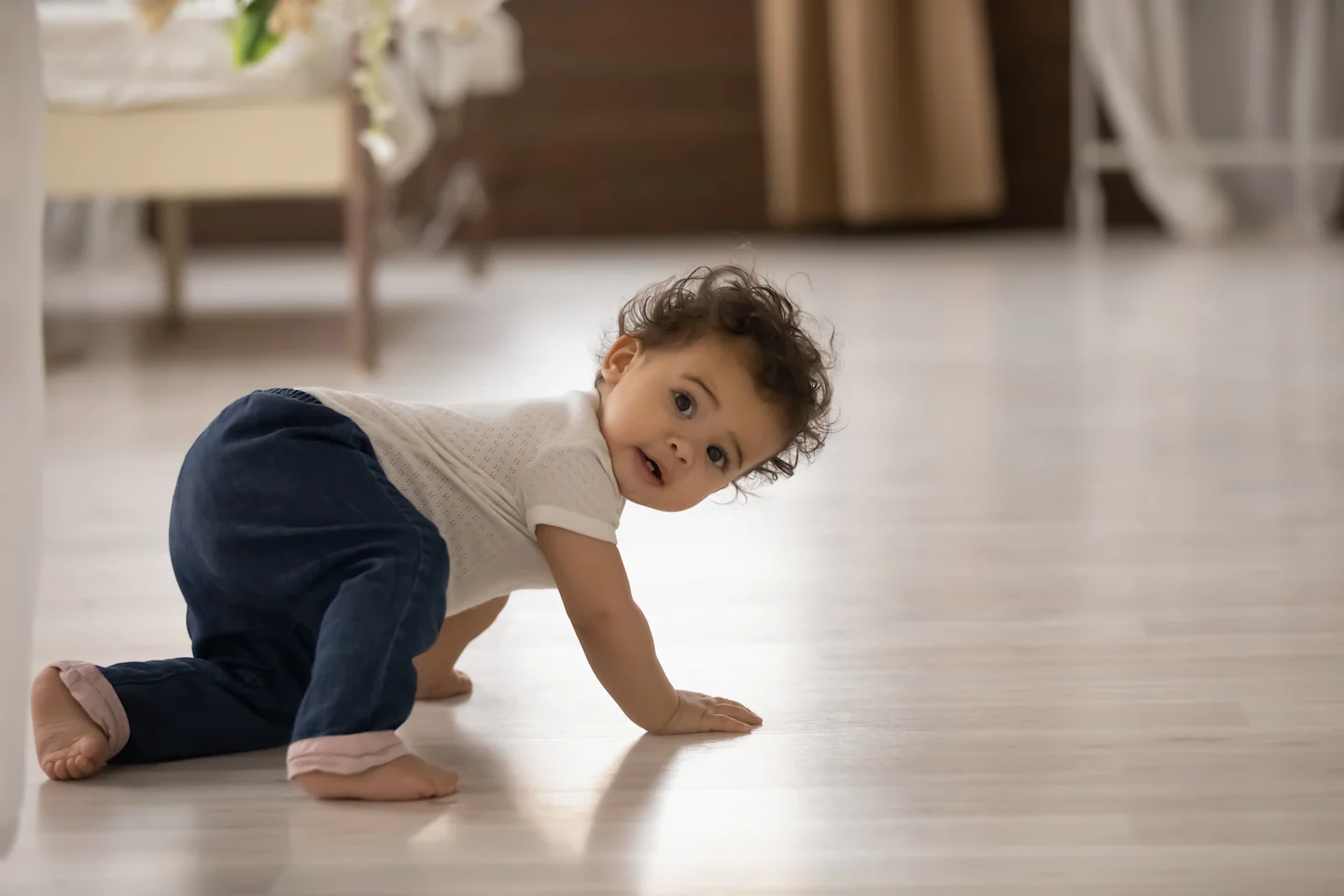 A baby doing a crab crawl on the floor.