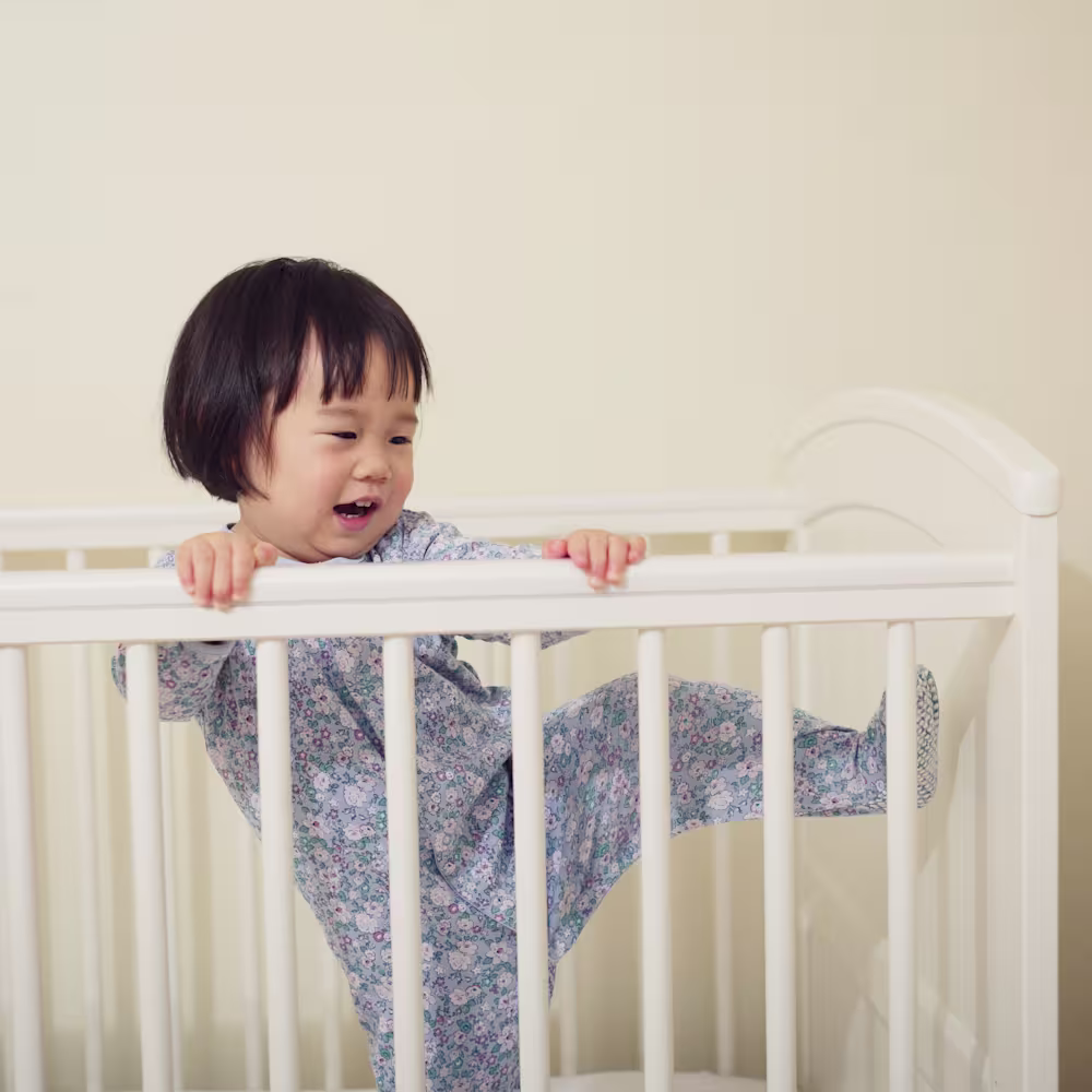 Toddler trying to climb out of crib.