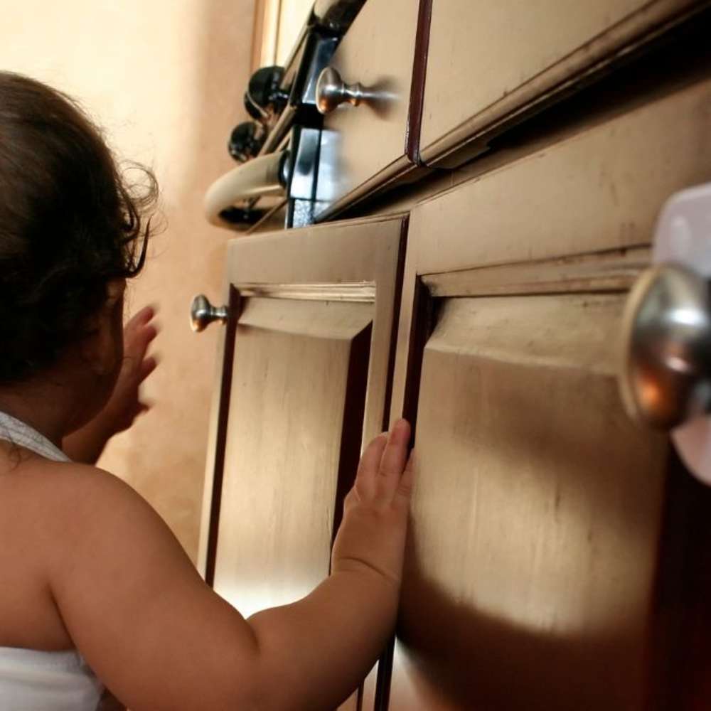 A baby trying to get into cabinets.