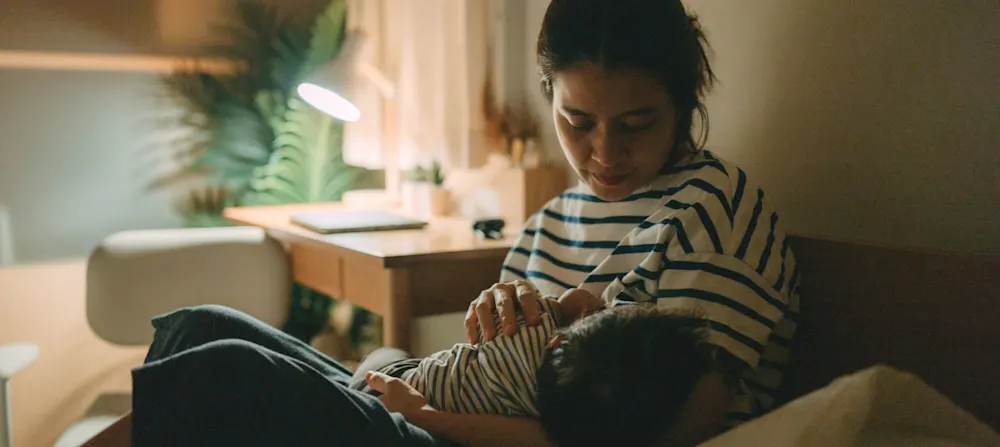 A mother feeding her baby at night.