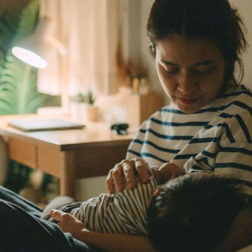 A mother feeding her baby at night.